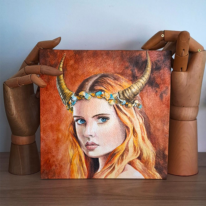 Aquarelle « Taurus » de Julie Vigneron exposée sur support, représentant une femme aux cornes de taureau sur fond terreux