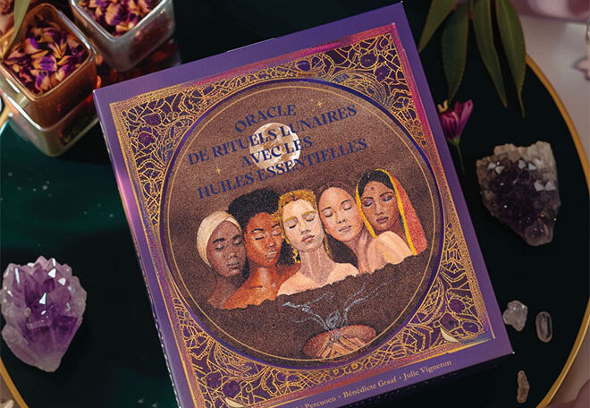 Box of the “Lunar Rituals Oracle with Essential Oils” illustrated by Julie Vigneron, surrounded by crystals, satin fabrics and dried flowers