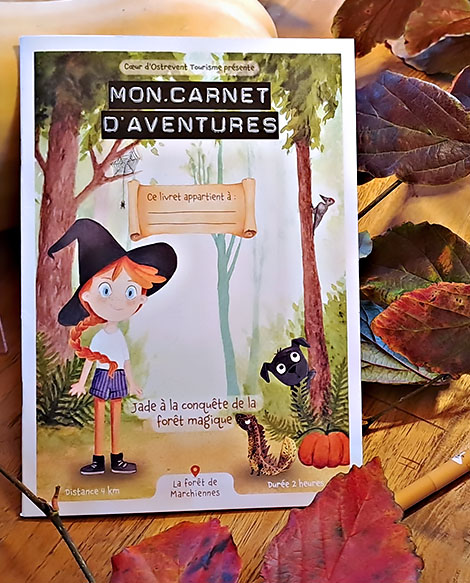 Illustration à l’aquarelle de la couverture du livret-jeu sur la forêt de Marchiennes, avec Jade la petite fille rousse, Pascal le triton doré et Fréquette le chien noir