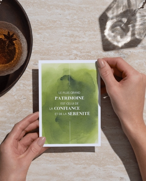 Carte de voeux avec une citation sur fond d'aquarelle abstraite, tenue par une femme.